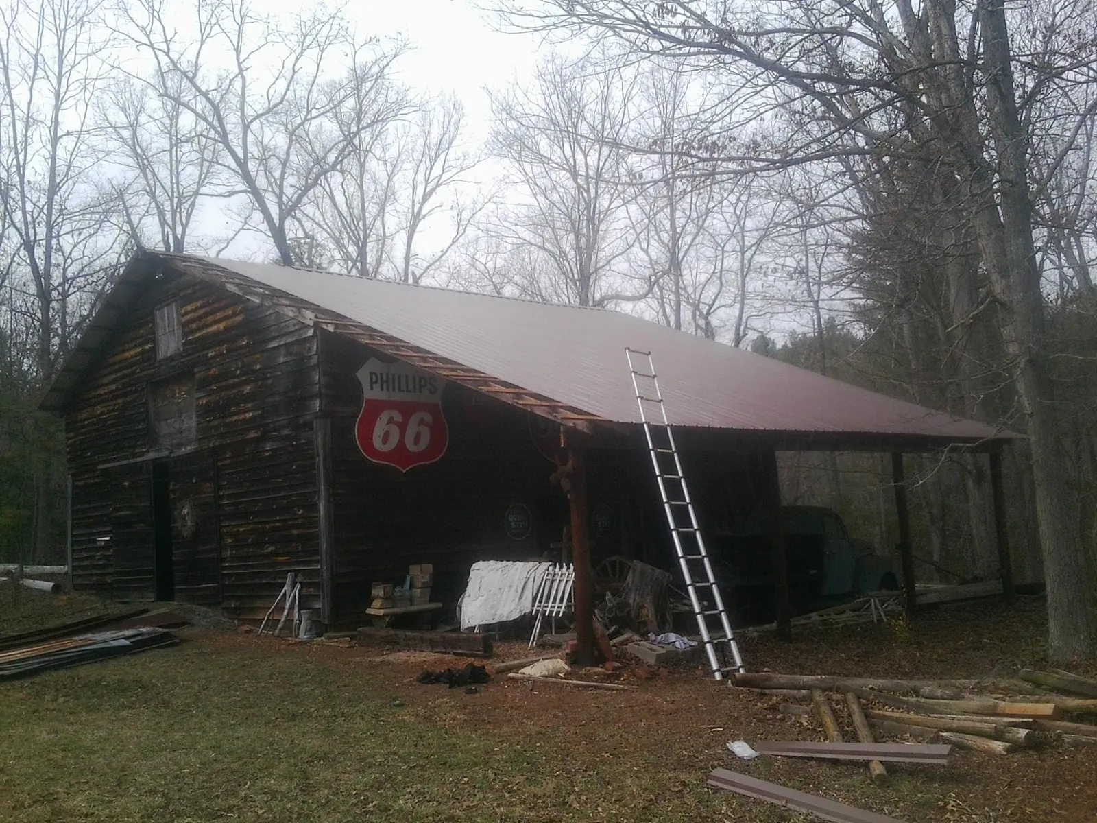 New metal roof on an open sided timber barn with a vintage sign in Peralta