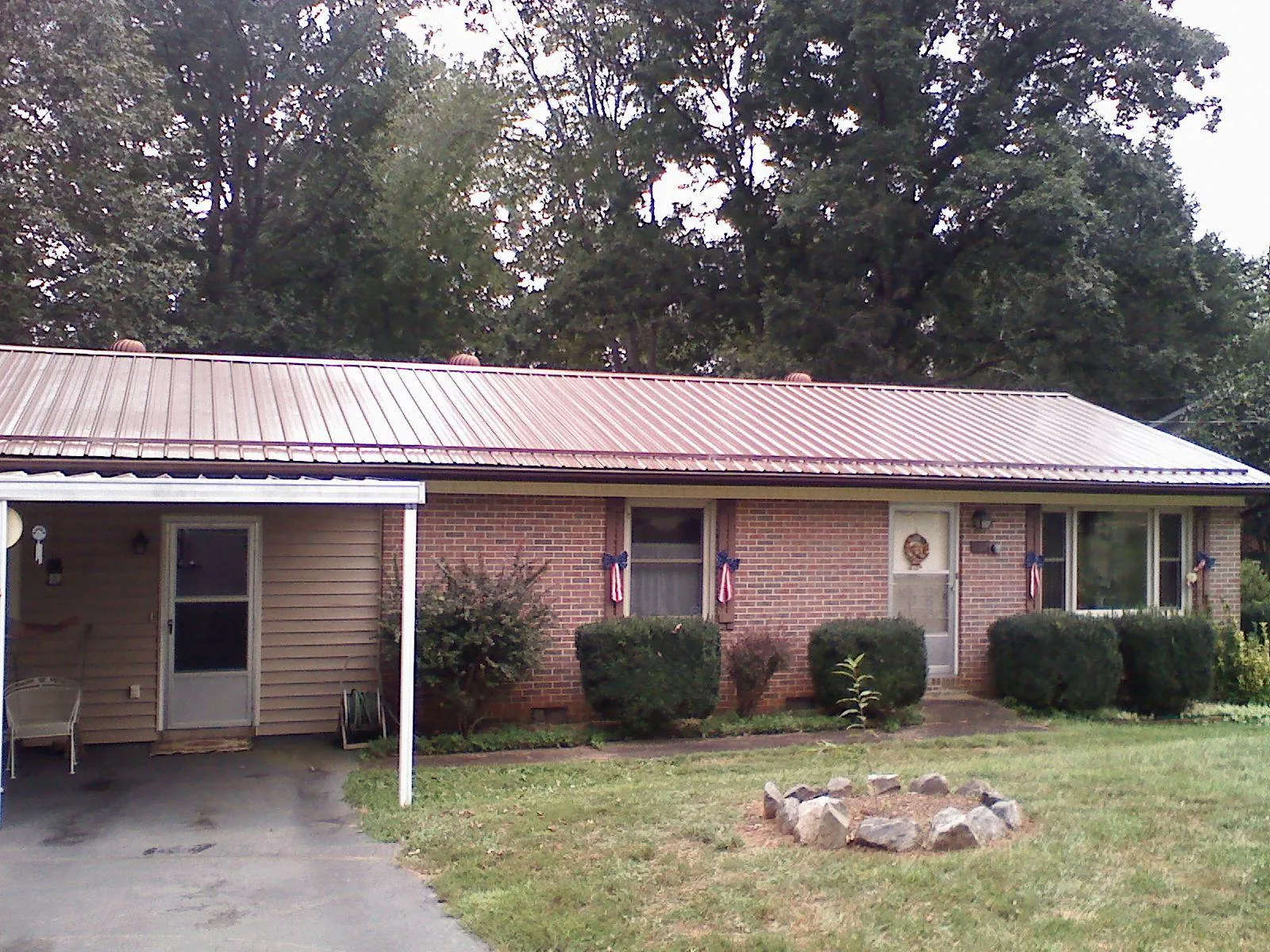 Bronze metal roof and carport on a brick ranch home — Roof Repair work by our crew in Peralta